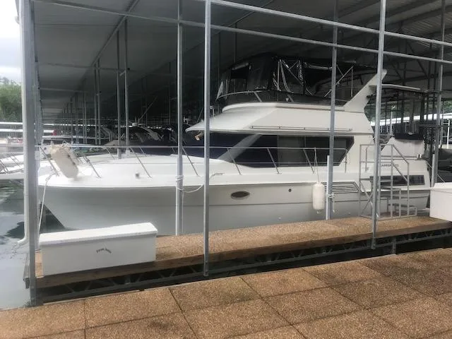 Slide: The Image of 1996 Carver 370 yacht docked in a marina under a covered slip. - 41