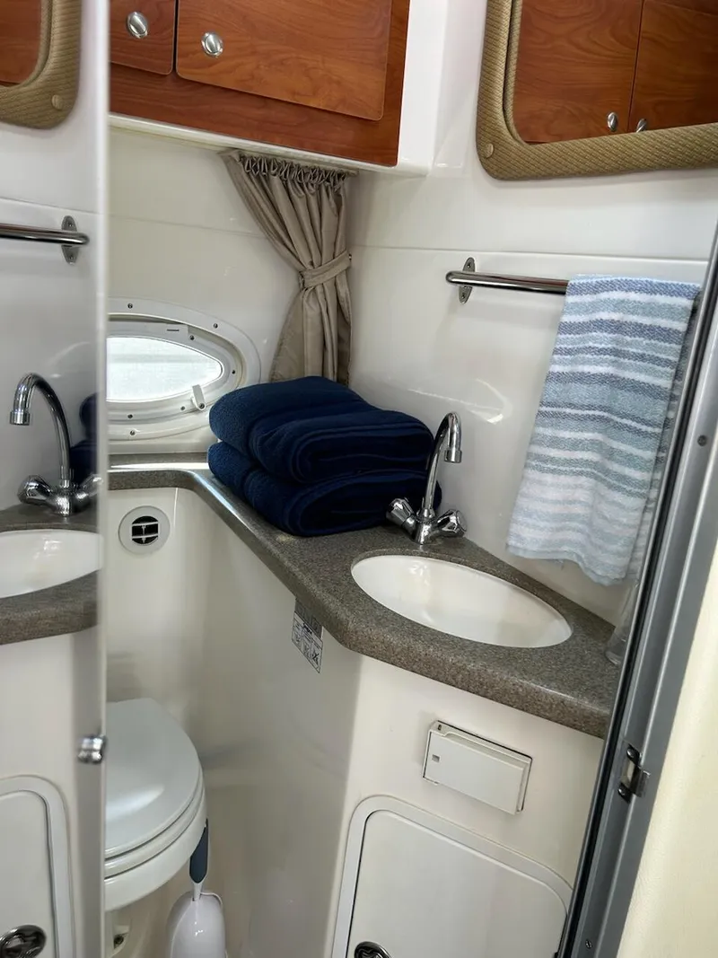 Slide: The Image of 2008 Rinker 350 Express Cruiser bathroom with sink, mirror, and storage cabinets. - 11