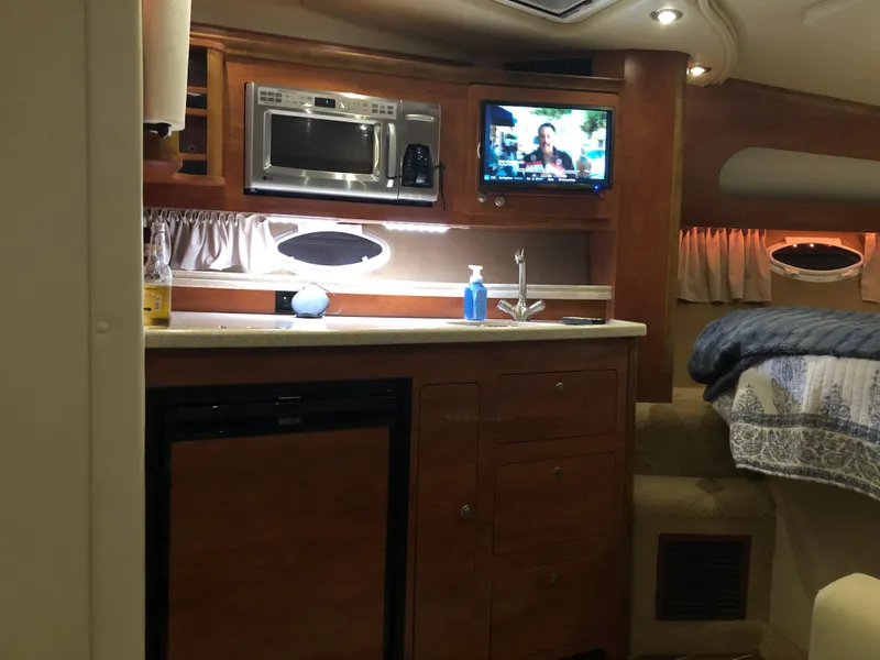 Slide: The Image of 2008 Rinker 350 Express Cruiser interior kitchen with microwave, TV, and sink. - 8