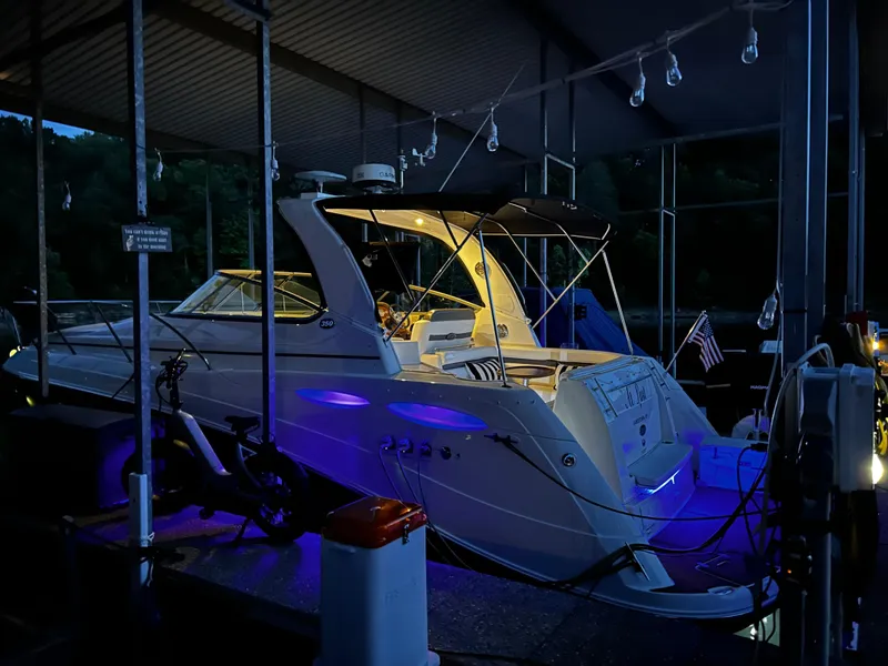 Slide: The Image of 2008 Rinker 350 Express Cruiser docked at night with blue and yellow lights. - 20