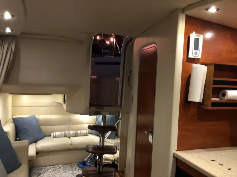 Slide: The Image of Interior of a 2008 Rinker 350 Express Cruiser with cozy seating and wooden accents. - 9