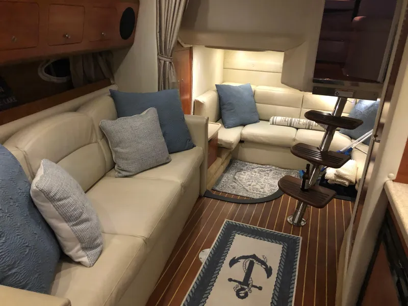 Slide: The Image of Interior of 2008 Rinker 350 Express Cruiser with beige leather seating and nautical decor. - 5