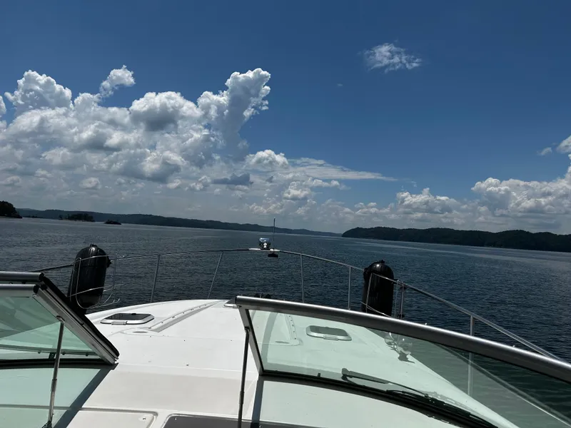 Slide: The Image of 2008 Rinker 350 Express Cruiser on a scenic lake under a blue sky with clouds. - 4