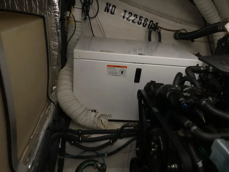 Slide: The Image of Engine compartment of a 2008 Rinker 350 Express Cruiser with generator and mechanical components. - 12