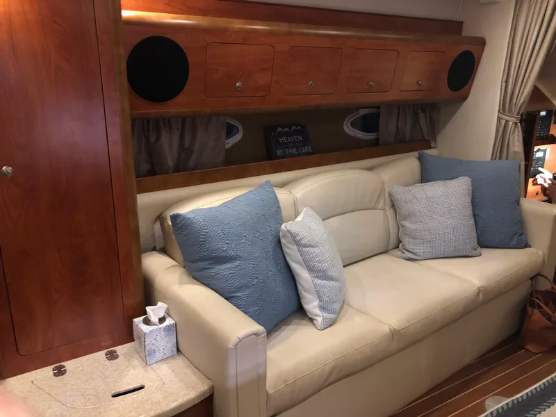 Slide: The Image of Interior of 2008 Rinker 350 Express Cruiser with beige sofa and blue cushions. - 7