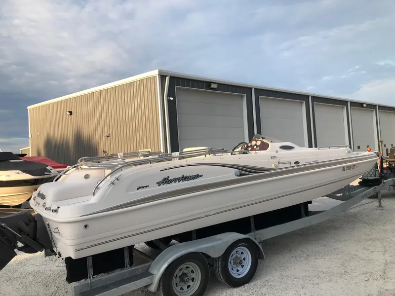 Slide: The Image of 2002 Hurricane Fun Deck GS 232 I/O boat on a trailer near storage facility. - 3