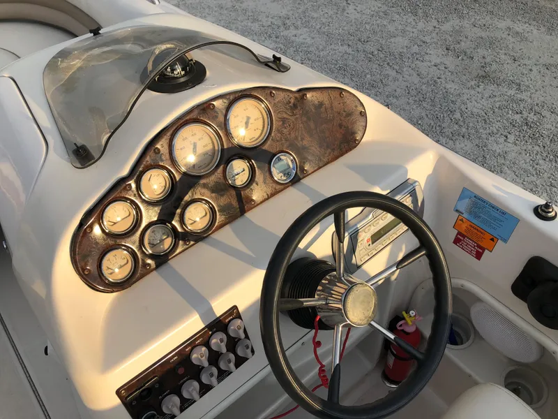 Slide: The Image of 2002 Hurricane Fun Deck GS 232 I/O boat dashboard with steering wheel and gauges. - 7