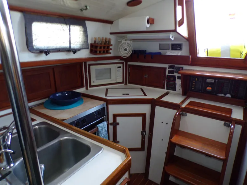Slide: The Image of 1994 Shannon 39 yacht kitchen with microwave, sink, and wooden cabinetry. - 10