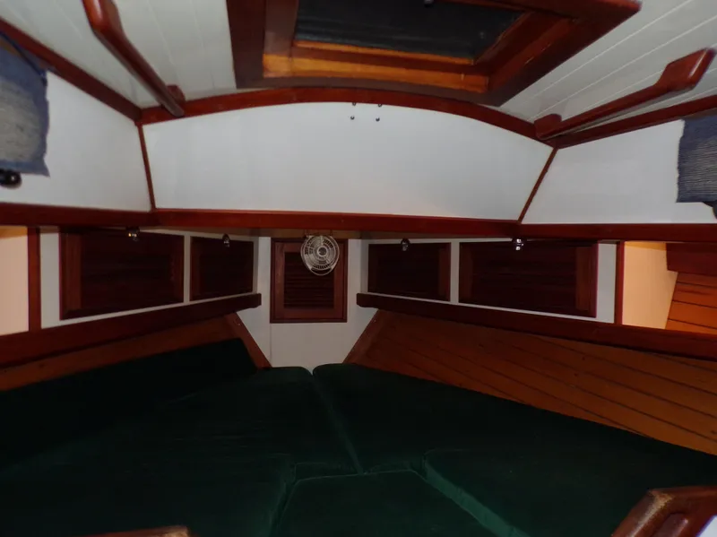 Slide: The Image of Cozy cabin interior of a 1994 Shannon 39 sailboat with wooden accents and green cushions. - 11