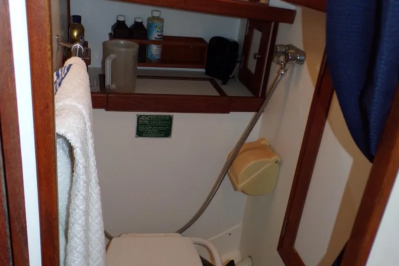 Slide: The Image of Compact bathroom in a 1994 Shannon 39 boat with shower and storage shelves. - 13