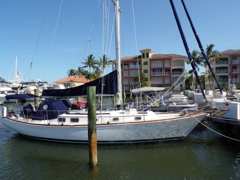 The Image of Sailboat docked at marina, Shannon 39 model, 1994, with buildings and palm trees in background. - 2