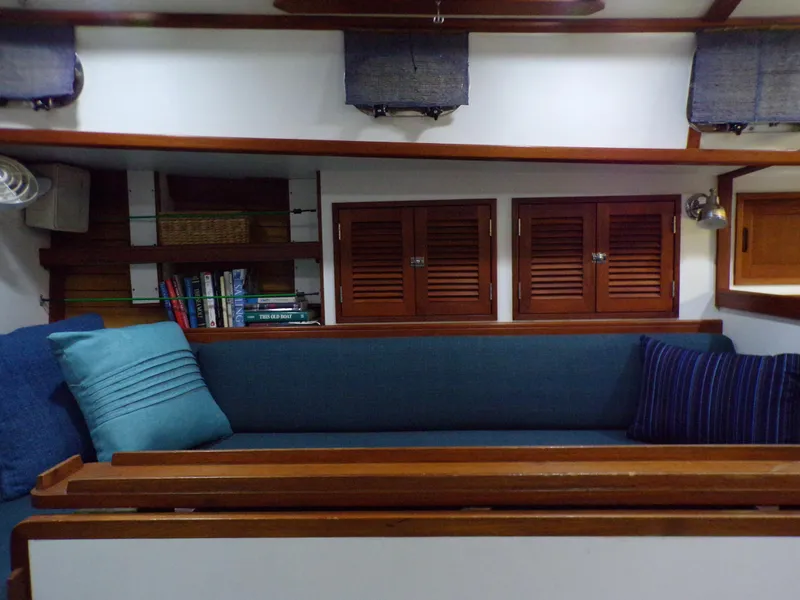 Slide: The Image of Cozy interior of 1994 Shannon 39 sailboat with blue cushions and wooden accents. - 8