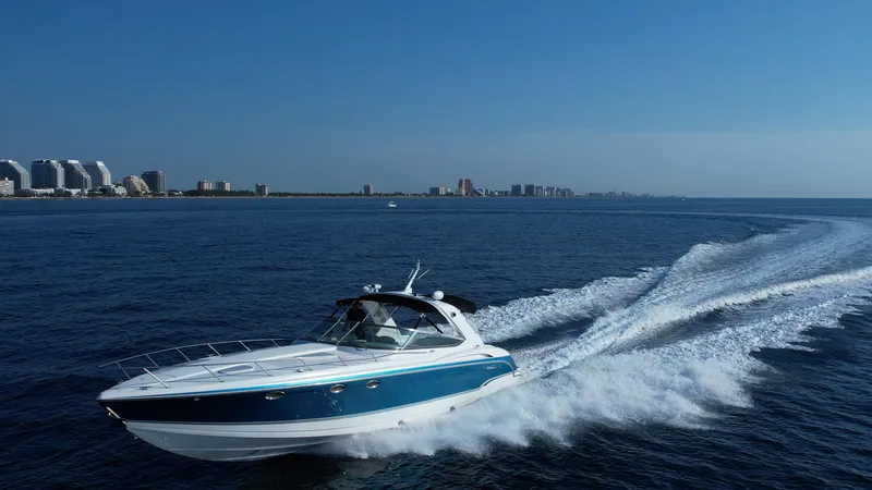 Slide: The Image of 2006 Formula 400 Super Sport boat cruising on open water near a coastal city. - 47
