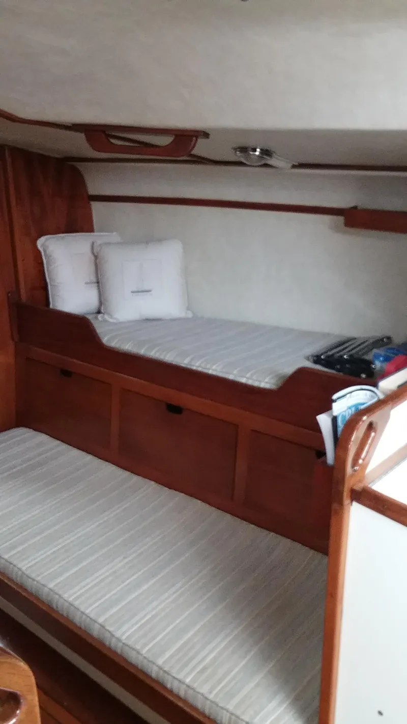 Slide: The Image of Interior cabin of a 1972 Tartan 41 sailboat with wooden furnishings and bunk beds. - 13