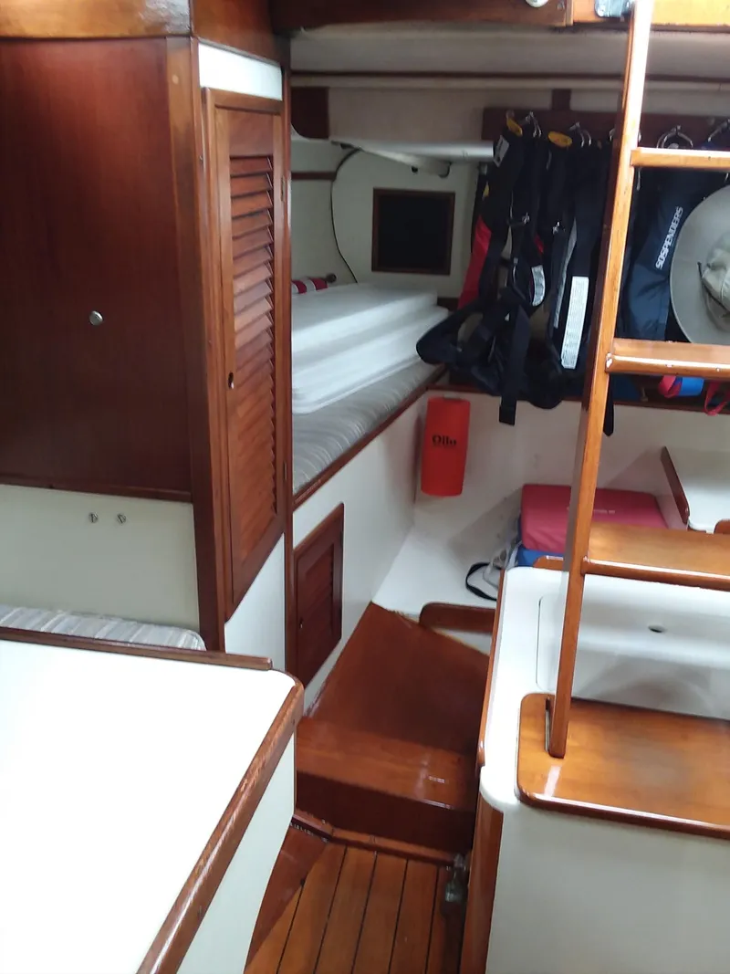 Slide: The Image of Interior of a 1972 Tartan 41 sailboat, featuring wooden cabinetry and cozy sleeping quarters. - 15