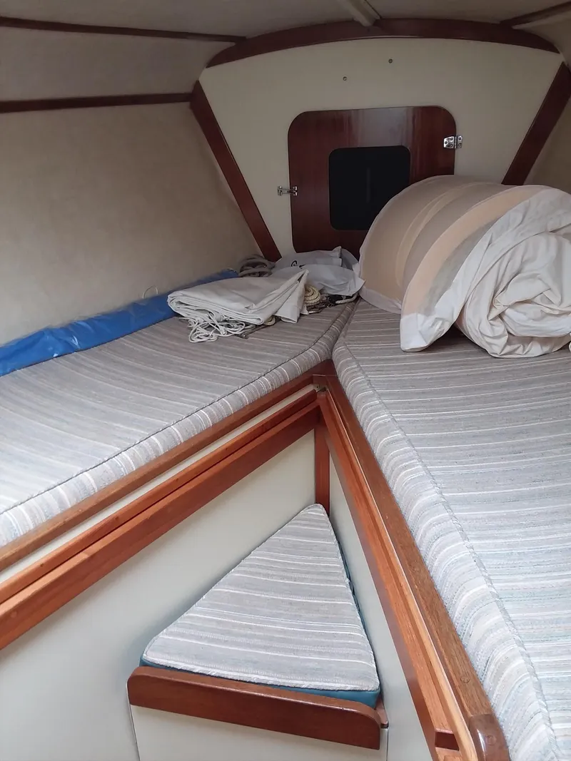 Slide: The Image of Interior cabin of a 1972 Tartan 41 sailboat with striped bedding and wooden trim. - 17