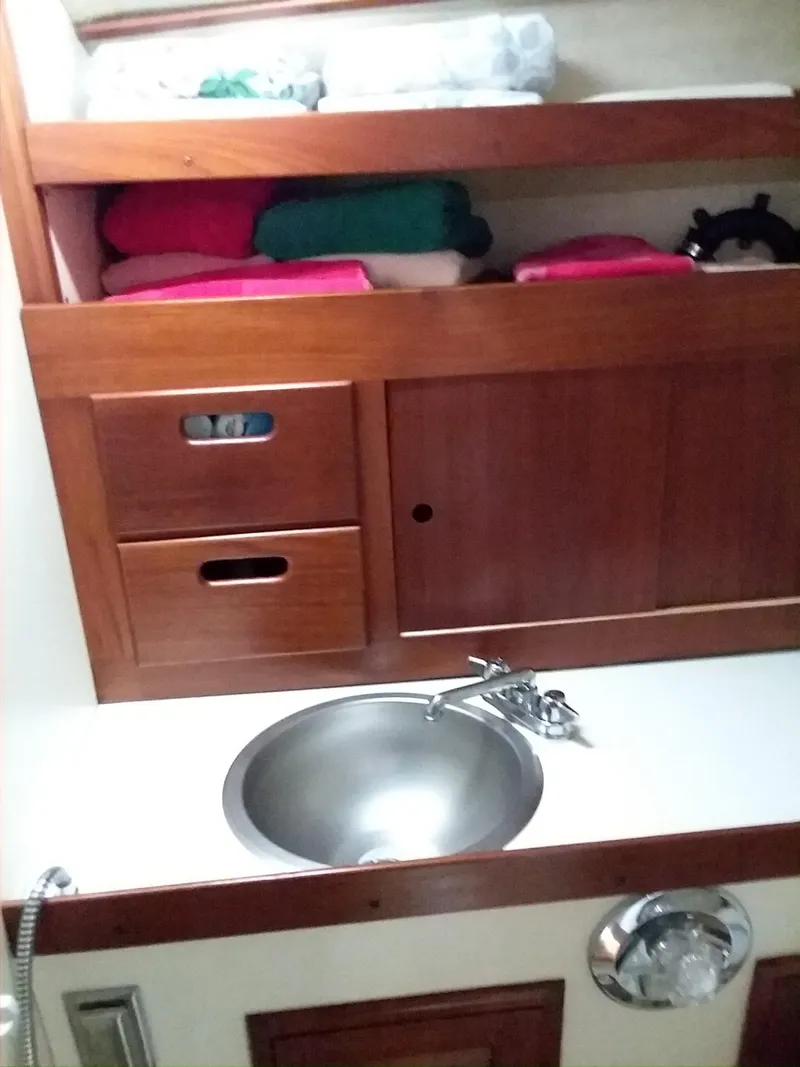 Slide: The Image of 1972 Tartan 41 yacht bathroom with wooden cabinets and stainless steel sink. - 18