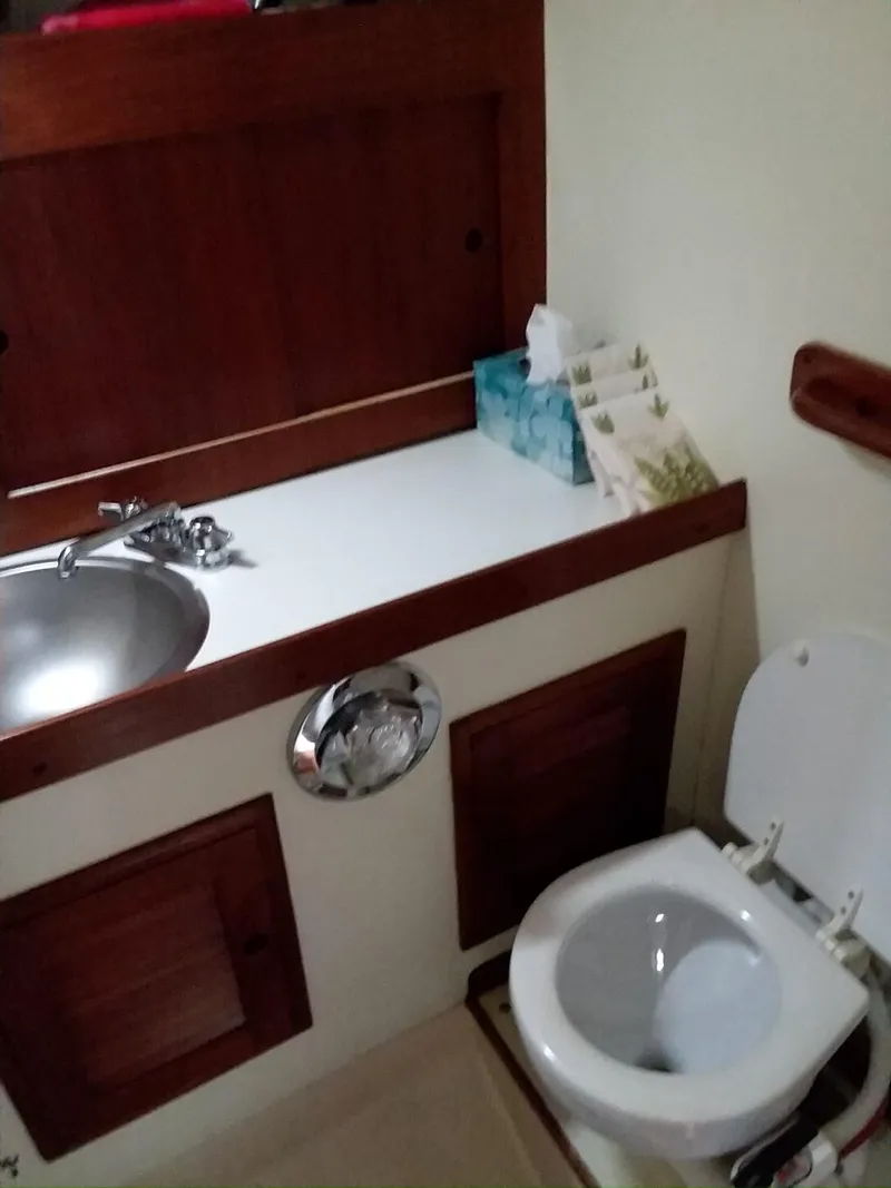 Slide: The Image of 1972 Tartan 41 yacht bathroom with sink, toilet, and wooden cabinetry. - 19