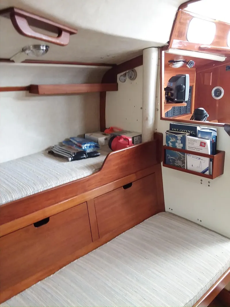 Slide: The Image of 1972 Tartan 41 yacht interior with wooden shelves and cozy sleeping area. - 20