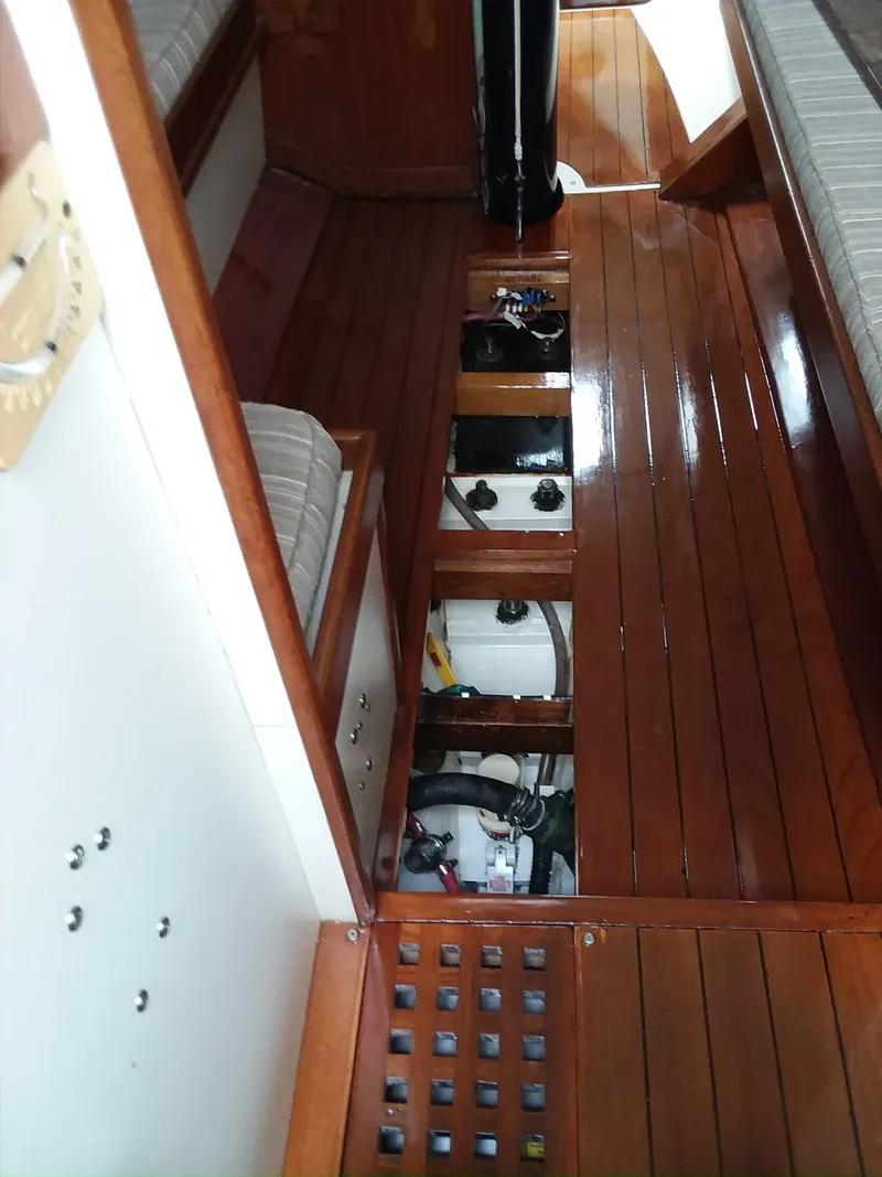 Slide: The Image of Interior view of a 1972 Tartan 41 sailboat with wooden flooring and open compartments. - 21