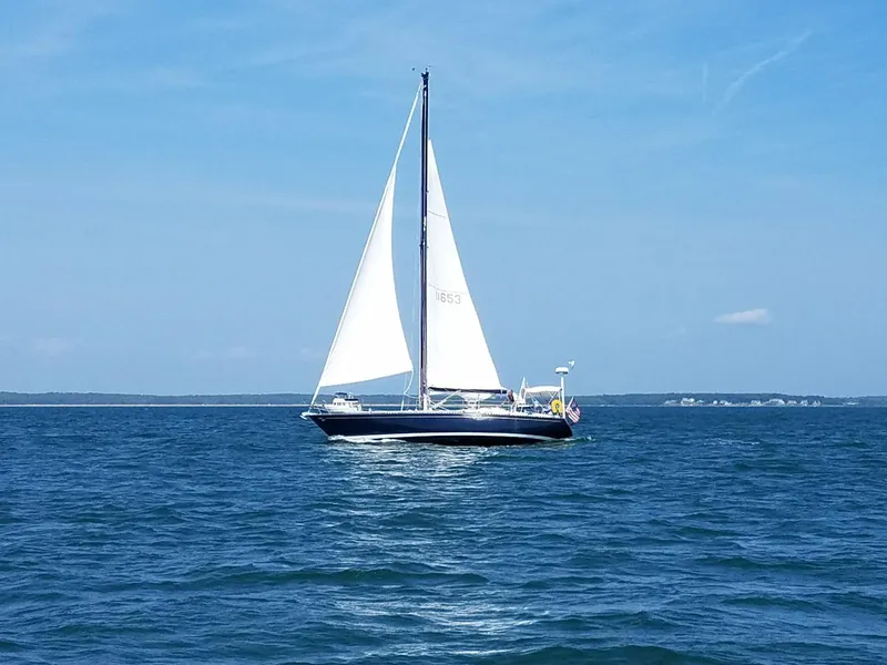 Slide: The Image of Sailboat Tartan 41 from 1972 on open water under clear blue sky. - 31