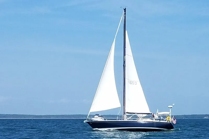 Slide: The Image of Sailboat Tartan 41 from 1972 sailing on open water under clear blue skies. - 32