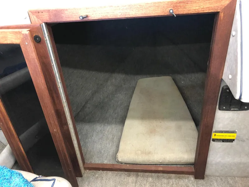 Slide: The Image of 1984 Sea Sprite 18' Cuddy Cabin interior with open wooden door and cushioned bed. - 10