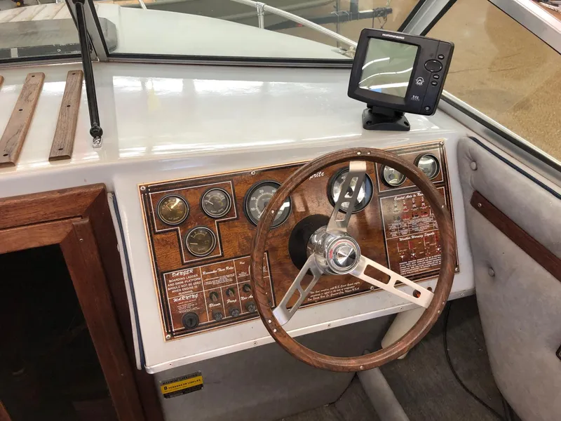 Slide: The Image of 1984 Sea Sprite 18' Cuddy Cabin boat dashboard with steering wheel and navigation instruments. - 7