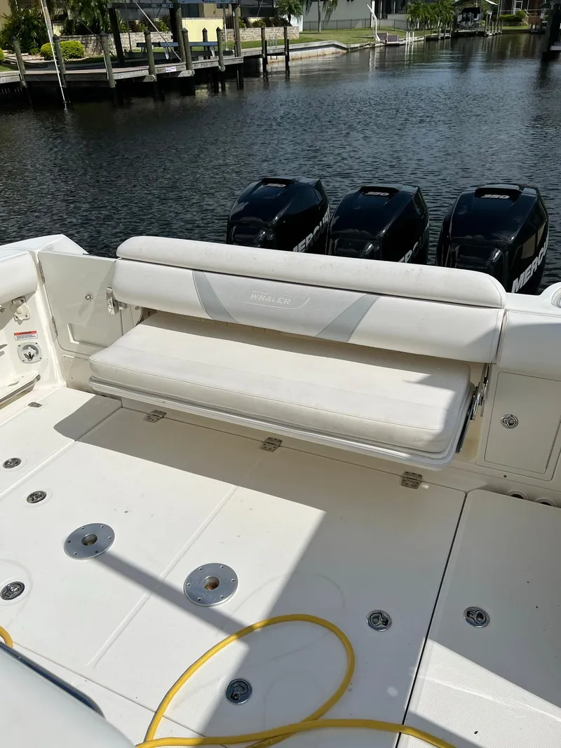 Slide: The Image of 2013 Boston Whaler 370 Outrage boat with triple outboard engines and fold-down seating. - 10