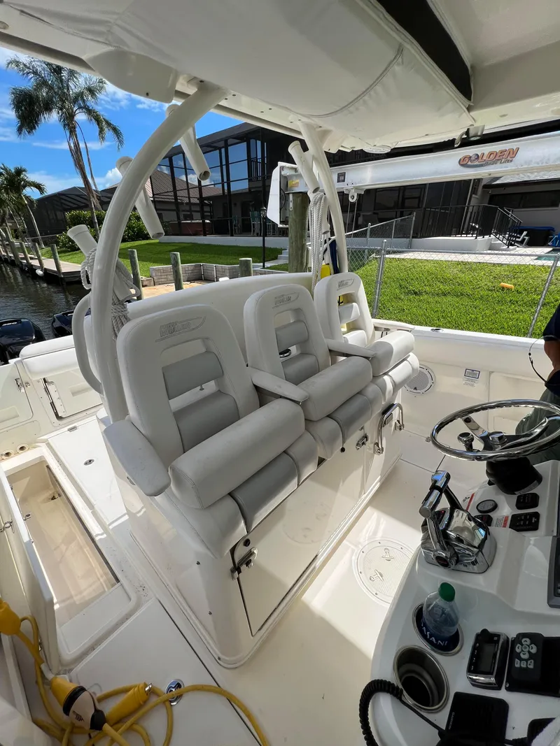 Slide: The Image of 2013 Boston Whaler 370 Outrage boat interior with white seating and control panel. - 5