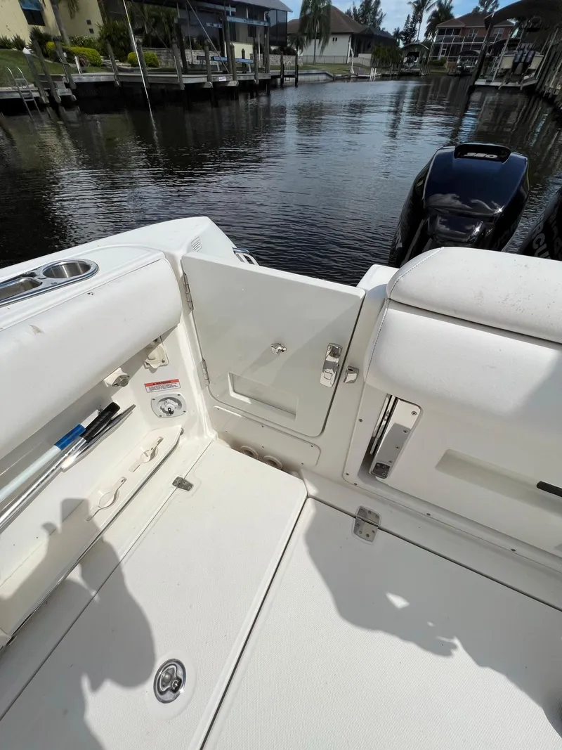 Slide: The Image of 2013 Boston Whaler 370 Outrage boat interior with open transom door by the water. - 8