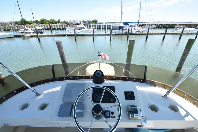 Slide: The Image of Helm of 2001 Camano 31 Trawler at marina, featuring steering wheel and controls. - 2