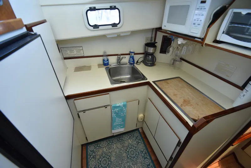 Slide: The Image of Compact kitchen in 2001 Camano 31 Trawler with sink, microwave, and coffee maker. - 32