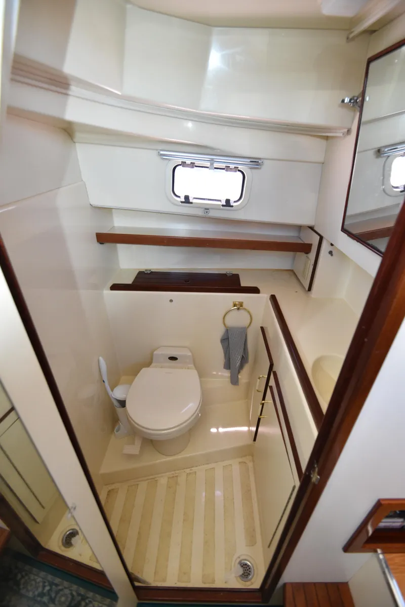 Slide: The Image of 2001 Camano 31 Trawler bathroom with toilet, sink, and storage shelves. - 37