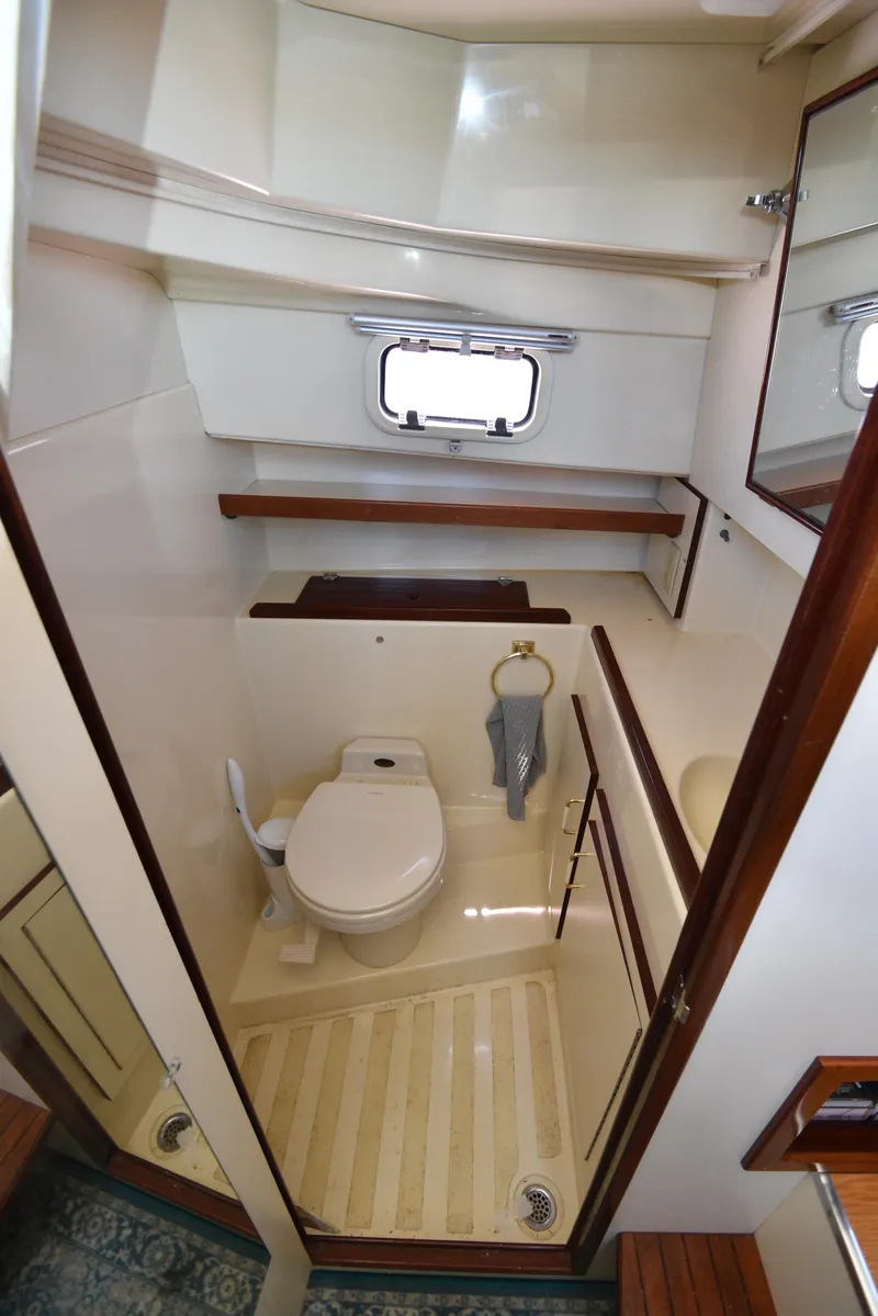 Slide: The Image of 2001 Camano 31 Trawler bathroom with toilet, sink, mirror, and window. - 39