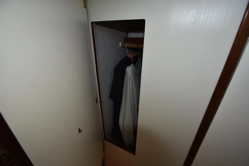 Slide: The Image of Small closet with hanging clothes inside a 2001 Camano 31 Trawler boat. - 41