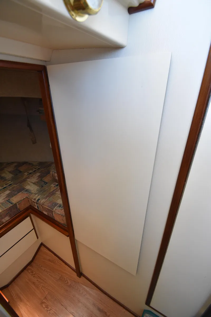 Slide: The Image of Interior cabin view of 2001 Camano 31 Trawler with wood trim and patterned bedding. - 44