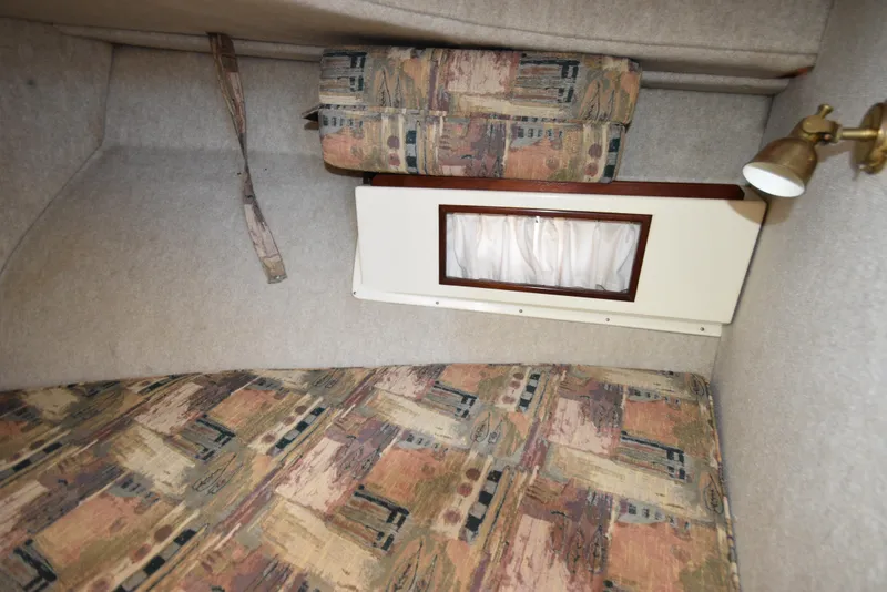 Slide: The Image of Interior cabin of 2001 Camano 31 Trawler with patterned upholstery and small window. - 47