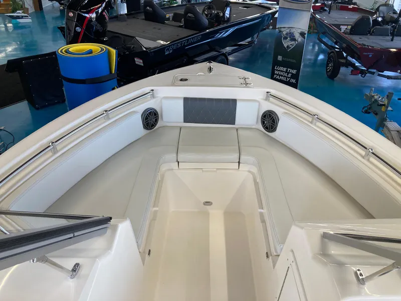 Slide: The Image of 2022 Cobia 220 Dual Console boat interior, bow seating area with speakers. - 10