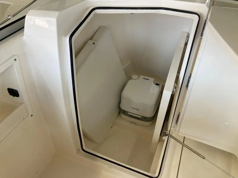 Slide: The Image of 2022 Cobia 220 Dual Console boat with built-in portable toilet. - 11