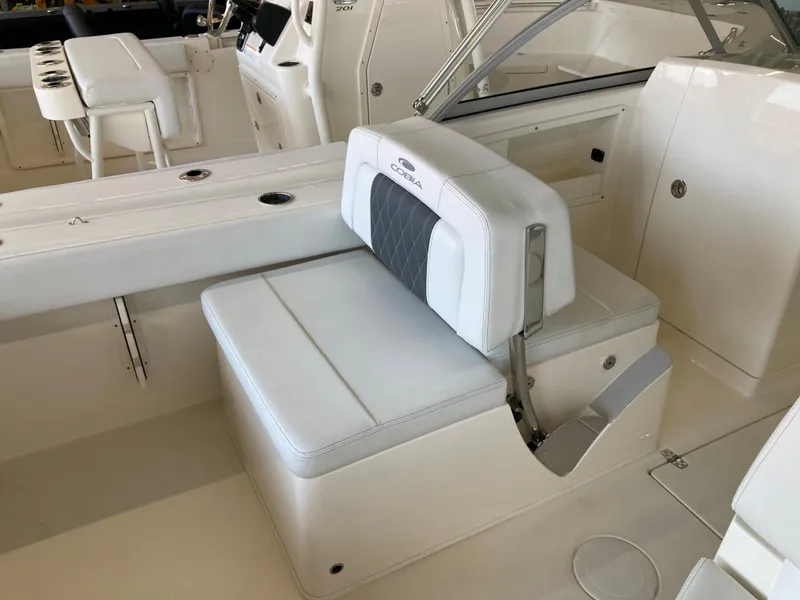 Slide: The Image of 2022 Cobia 220 Dual Console boat interior with white seating and storage. - 5