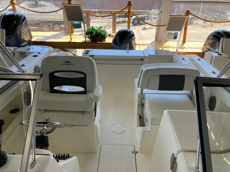 Slide: The Image of 2022 Cobia 220 Dual Console boat interior with seating and controls. - 7