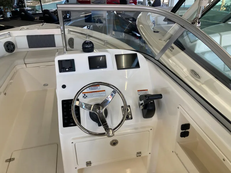 Slide: The Image of 2022 Cobia 220 Dual Console boat dashboard with steering wheel and controls. - 9