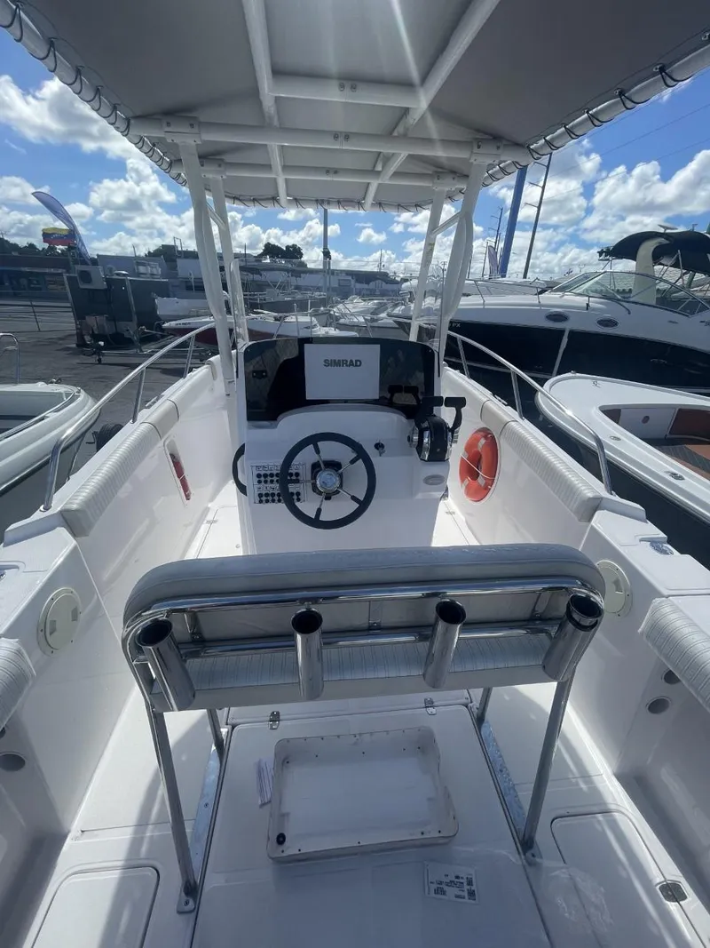 Slide: The Image of 2022 Wellcraft 275cc center console boat interior with steering wheel and seating. - 12