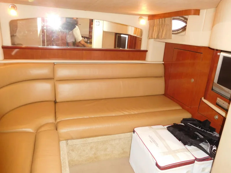 Slide: The Image of 2005 Sea Ray 420 Sundancer interior with tan leather seating and wooden cabinetry. - 35