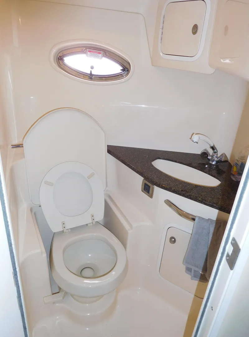 Slide: The Image of 2005 Sea Ray 420 Sundancer bathroom with toilet, sink, and porthole window. - 39