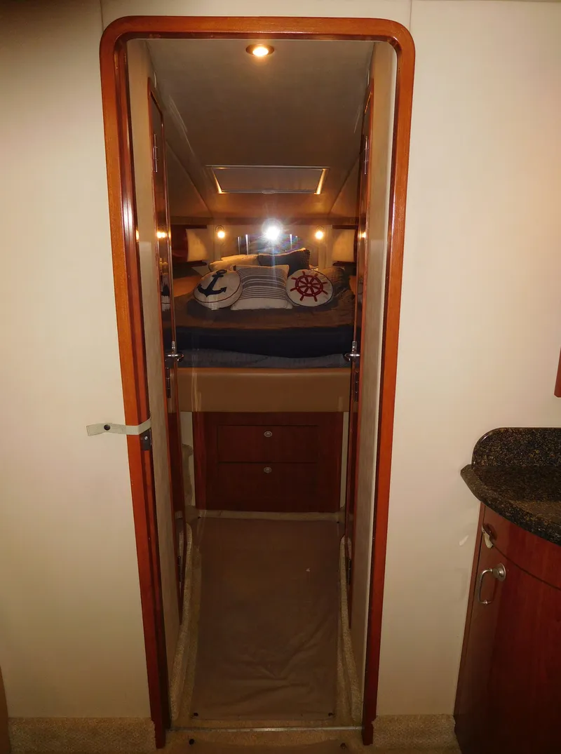 Slide: The Image of 2005 Sea Ray 420 Sundancer cabin interior with cozy bed and nautical decor. - 40