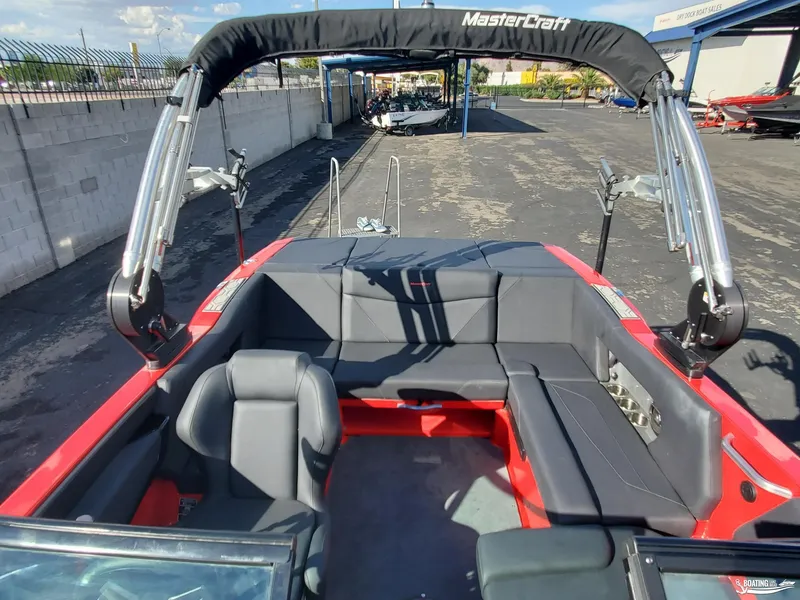 Slide: The Image of 2020 MasterCraft NXT20 boat interior with black seating and red accents. - 17