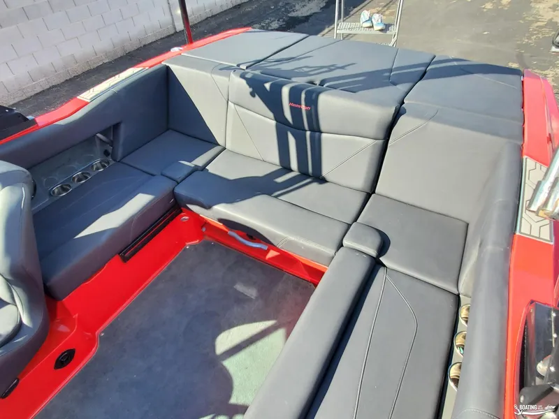 Slide: The Image of 2020 MasterCraft NXT20 boat interior with gray seating and red accents. - 19