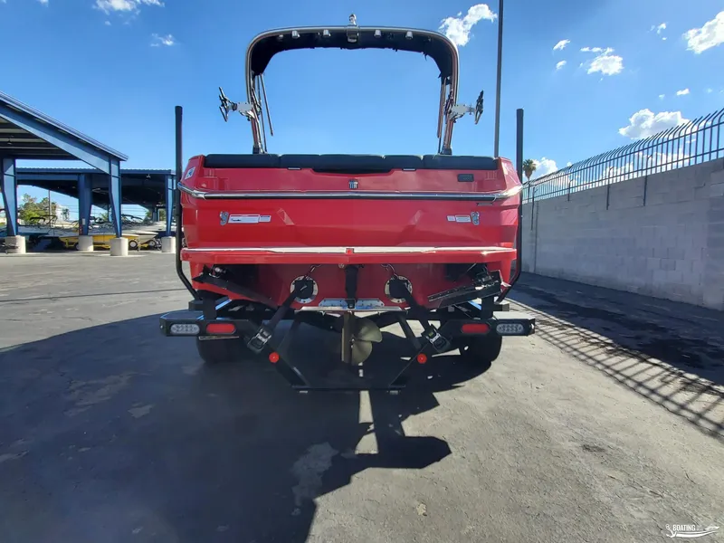 Slide: The Image of 2020 MasterCraft NXT20 boat, rear view, red color, parked outdoors under blue sky. - 9
